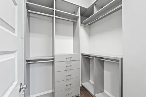 a view of walk in closet with empty racks