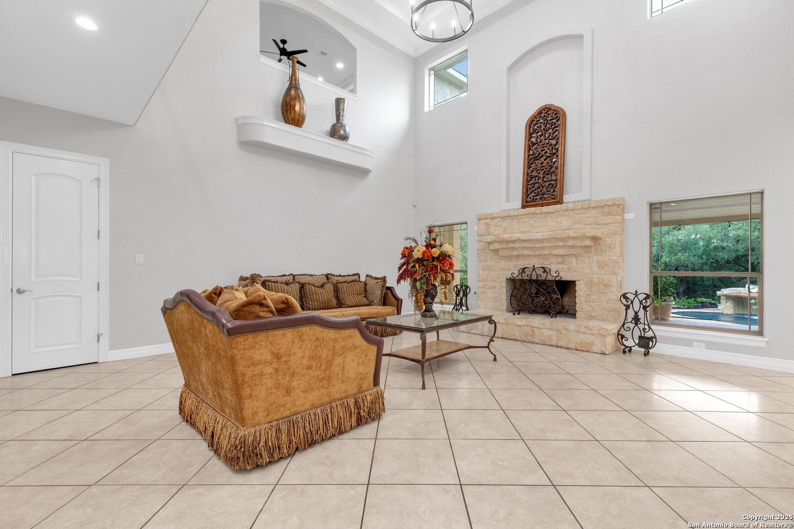 1130 Whispering Water Spring Branch, TX 78070 - Photo 5 of 43 a living room with furniture a fireplace and a floor to ceiling window