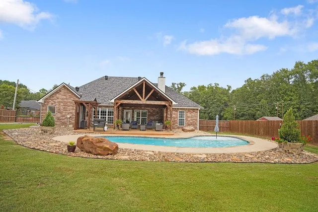 a front view of a house with a garden and lake view