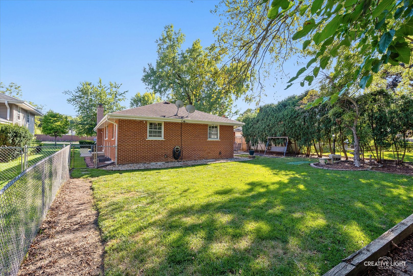 1800 East Algonquin Road Des Plaines, IL 60016 - Photo 24 of 26 a backyard of a house with table and chairs under an umbrella