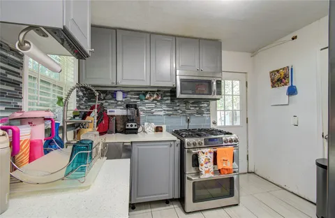 a kitchen with stainless steel appliances granite countertop a stove and a microwave