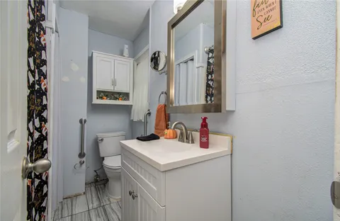 a bathroom with a sink toilet and a mirror