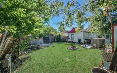 a patio with sofas table and chairs with wooden fence and plants