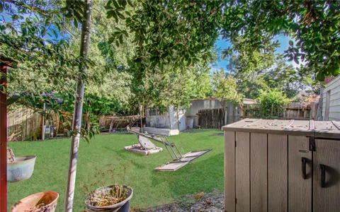 a view of a backyard with table and chairs potted plants and wooden fence