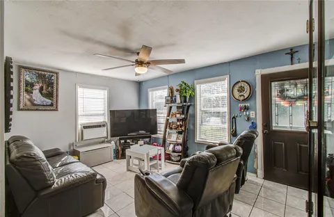 a living room with furniture a window and a flat screen tv
