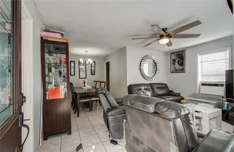 a living room with furniture a chandelier and a window