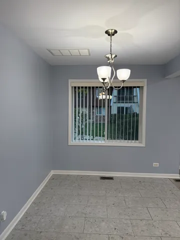 a view of wooden floor and a chandelier in a room