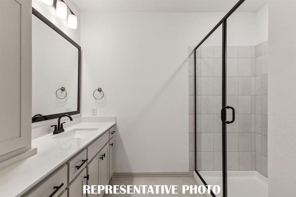 1009 Splitrock Drive Allen, TX 75013 - Photo 12 of 20 a bathroom with a shower sink and mirror