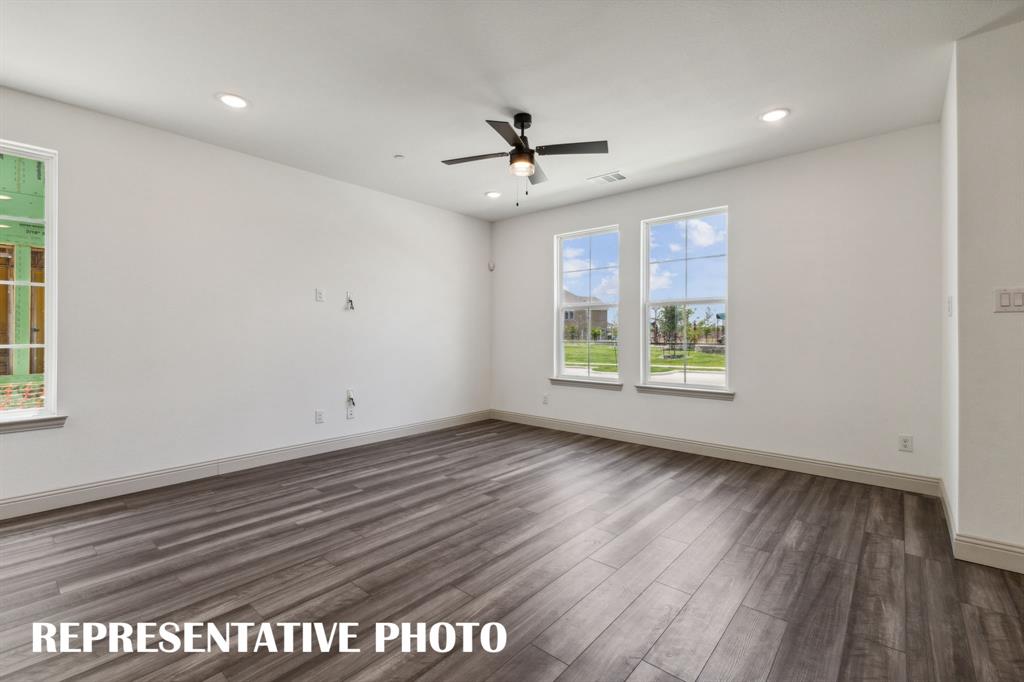 1009 Splitrock Drive Allen, TX 75013 - Photo 4 of 20 an empty room with wooden floor a ceiling fan and windows