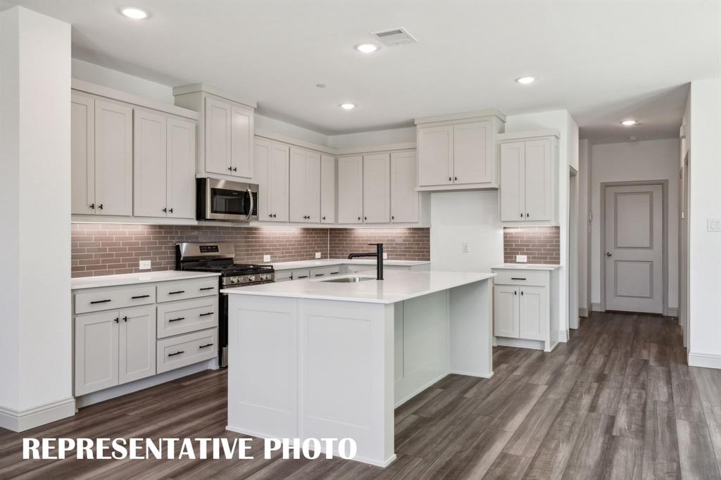 1009 Splitrock Drive Allen, TX 75013 - Photo 8 of 20 a kitchen with kitchen island white cabinets and refrigerator