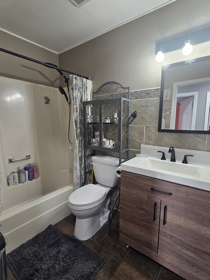 1353 Spring Valley Drive Carol Stream, IL 60188 - Photo 16 of 25 a bathroom with a sink toilet vanity and shower