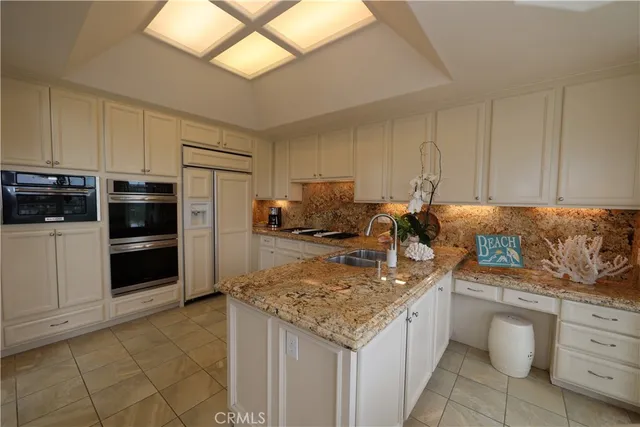 a kitchen with granite countertop a sink and cabinets