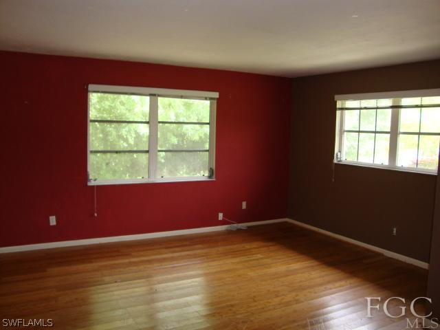 19055 Evergreen Road Fort Myers, FL 33967 - Photo 2 of 9 an empty room with wooden floor and windows