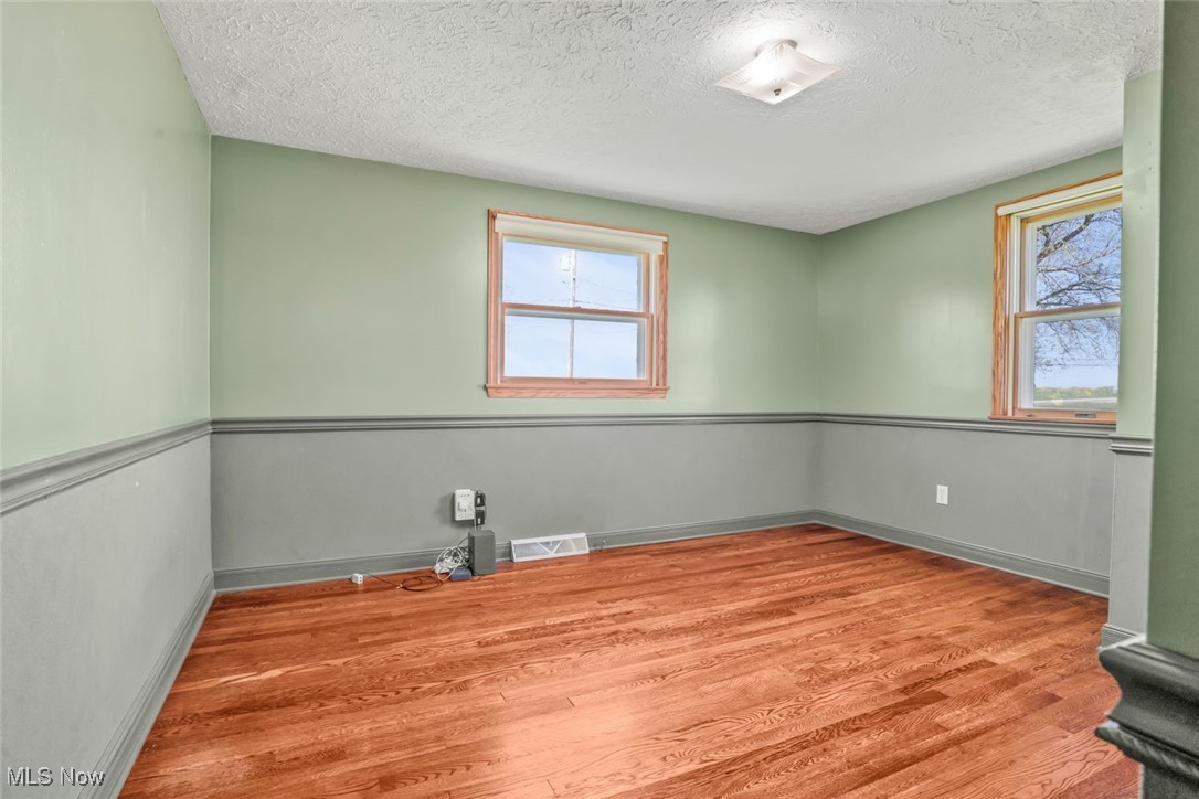 260 Barnard Road Wooster, OH 44691 - Photo 26 of 40 Empty room with a textured ceiling, wood finished floors, plenty of natural light, and visible vents