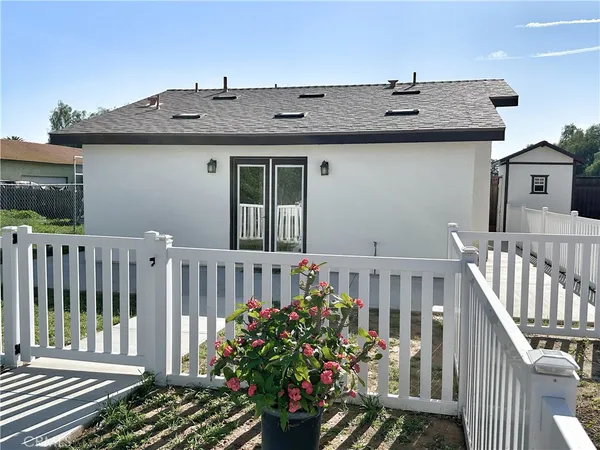 a view of a house with wooden deck and furniture