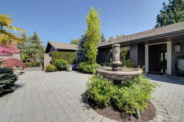 a kitchen with stainless steel appliances granite countertop a stove top oven a sink dishwasher a dining table and chairs with wooden floor