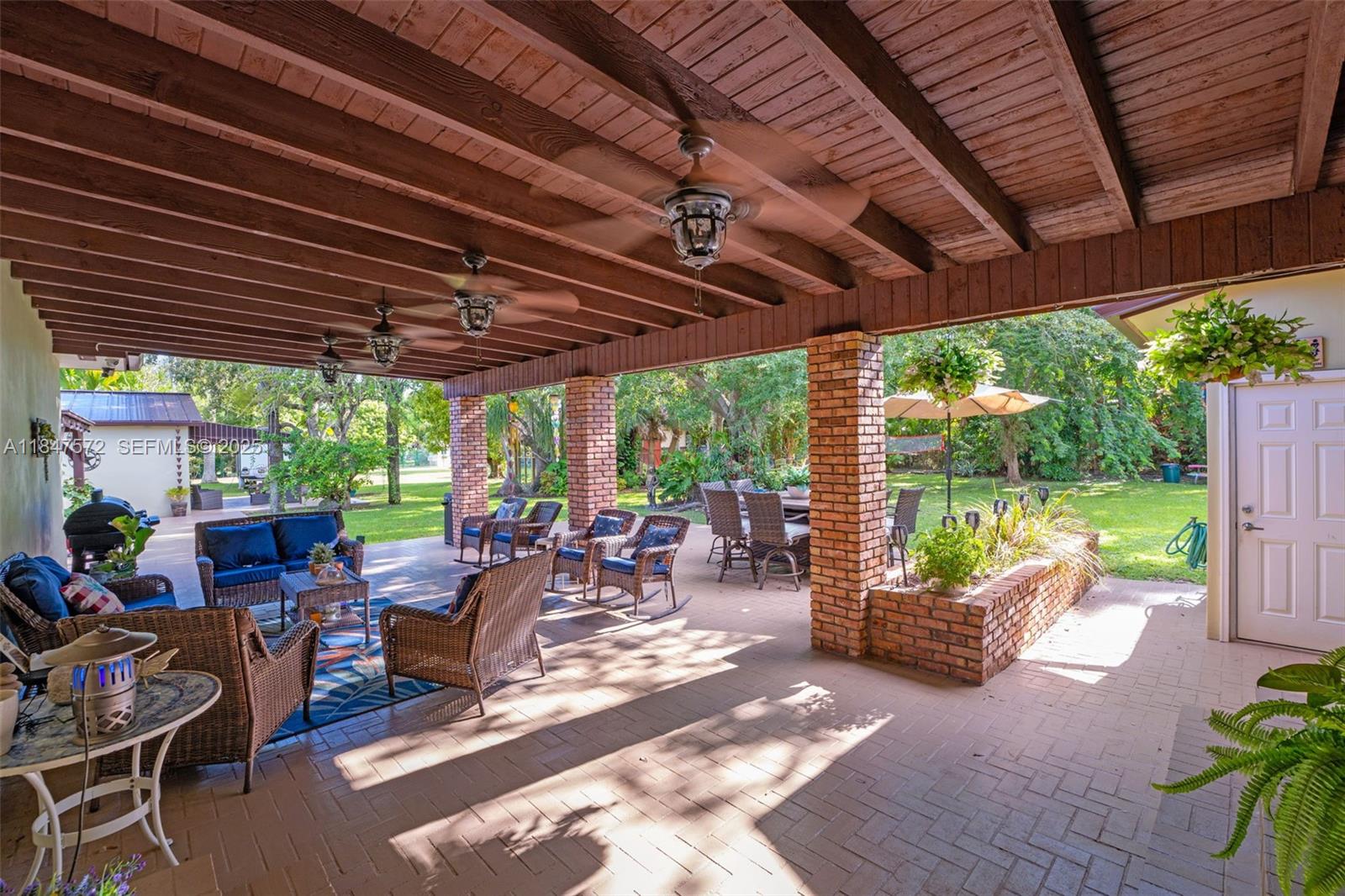 18200 Southwest 296th Street Homestead, FL 33030 - Photo 25 of 55 a view of a patio with table and chairs potted plants with wooden floor and fence
