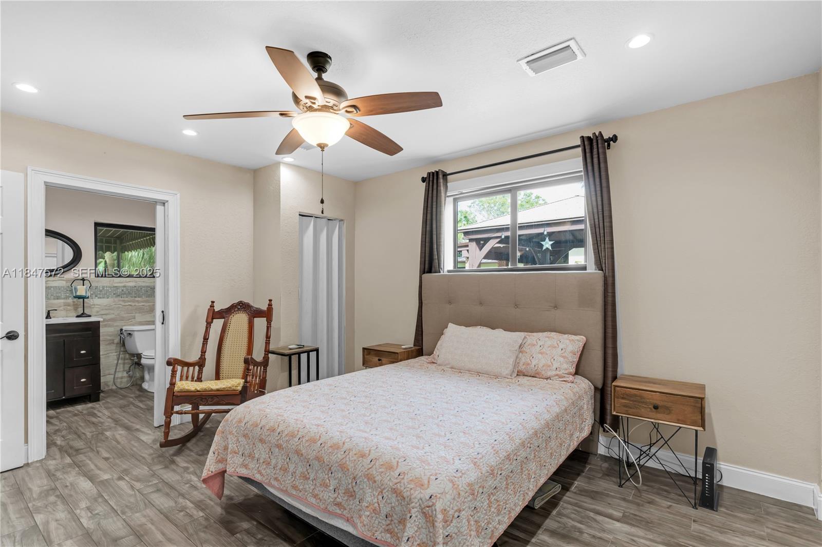 18200 Southwest 296th Street Homestead, FL 33030 - Photo 41 of 55 a bedroom with a bed a flat screen tv and couches