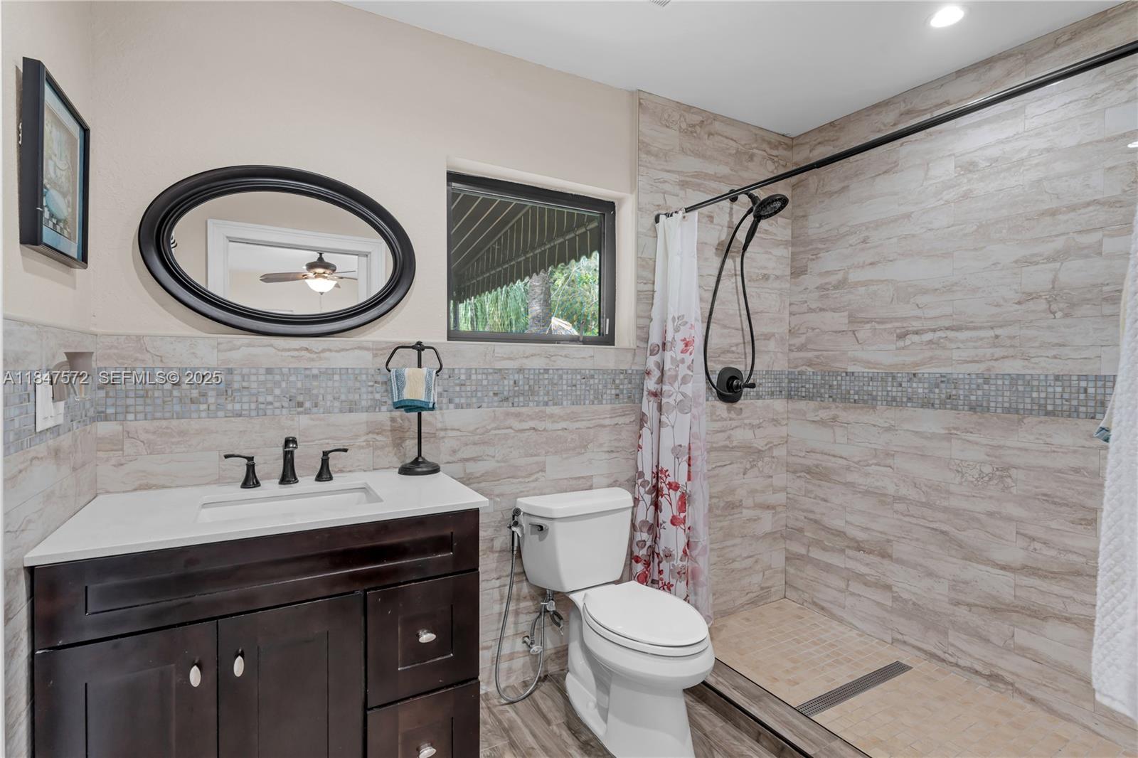 18200 Southwest 296th Street Homestead, FL 33030 - Photo 42 of 55 a bathroom with a toilet a sink and a mirror