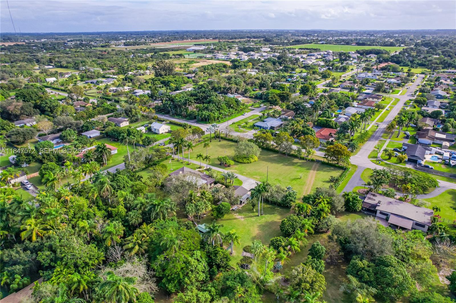 18200 Southwest 296th Street Homestead, FL 33030 - Photo 54 of 55 a view of a lush green field with plants and trees in the background