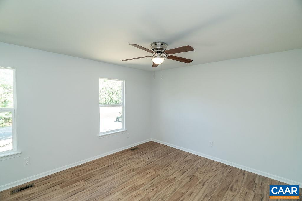 2087 Commonwealth Drive Charlottesville, VA 22901 - Photo 17 of 44 an empty room with wooden floor fan and windows