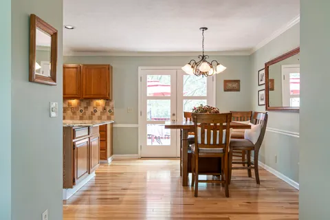 a view of a a dining room with furniture window and wooden floor