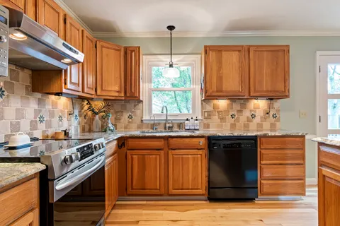 a kitchen with stainless steel appliances granite countertop a sink stove and refrigerator