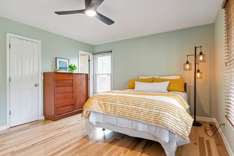 a bedroom with a bed and wooden floor