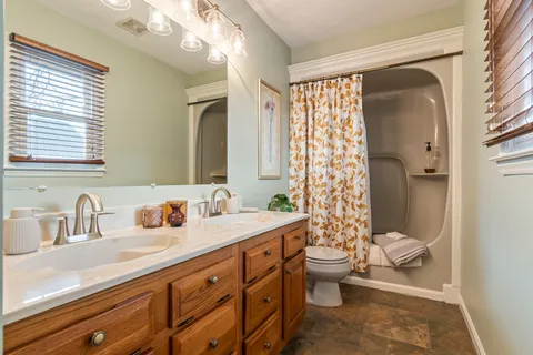 a bathroom with a double vanity sink toilet and shower