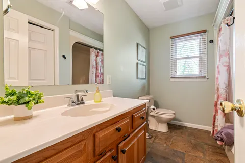a bathroom with a sink vanity granite and toilet