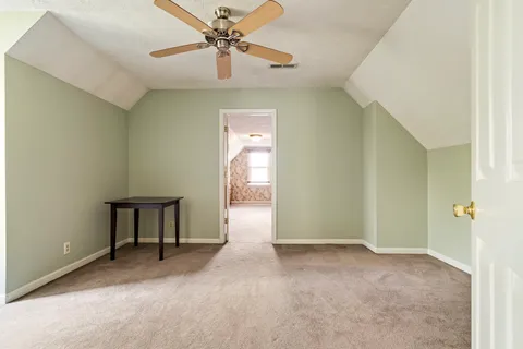 a view of a hallway with a chandelier fan and windows