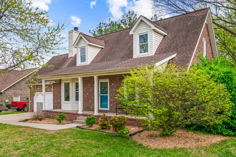 a front view of a house with a yard and potted plants