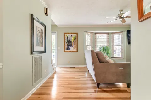 a view of a livingroom with wooden floor and furniture
