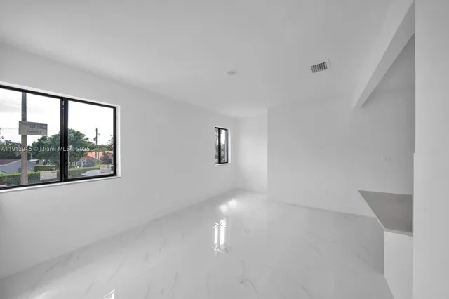 a picture of a room with wooden floor and windows