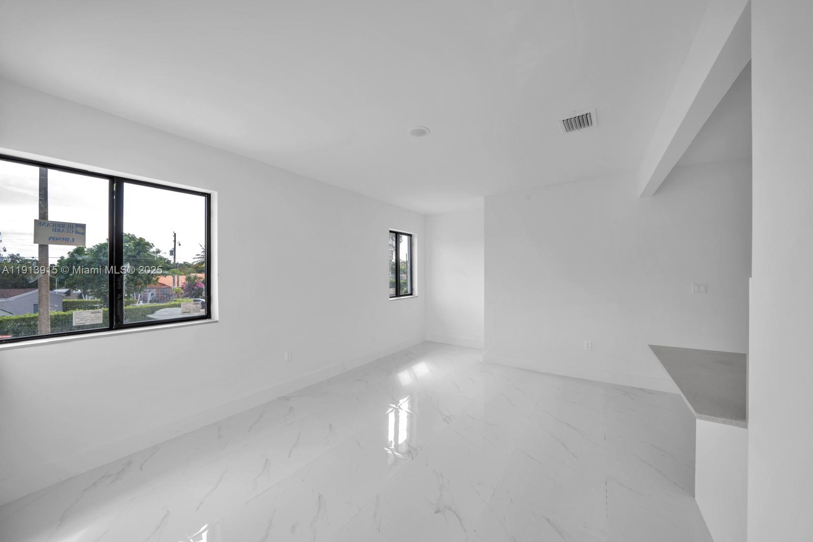 450 Beacom Boulevard, Unit B Miami, FL 33135 - Photo 2 of 11 a picture of a room with wooden floor and windows