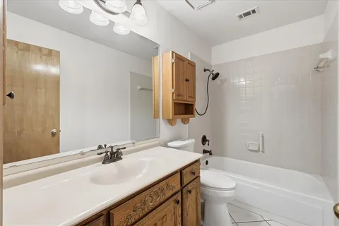 an empty room with wooden floor chandelier fan and windows