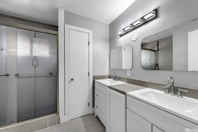 a bathroom with a double vanity sink and a mirror