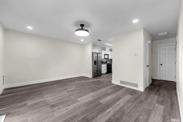 a view of empty room with wooden floor