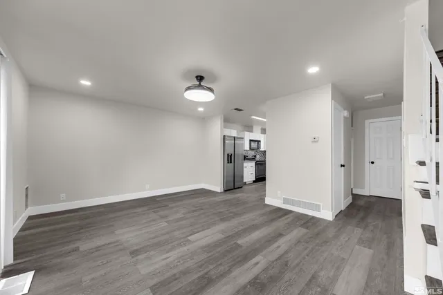 a view of empty room with wooden floor