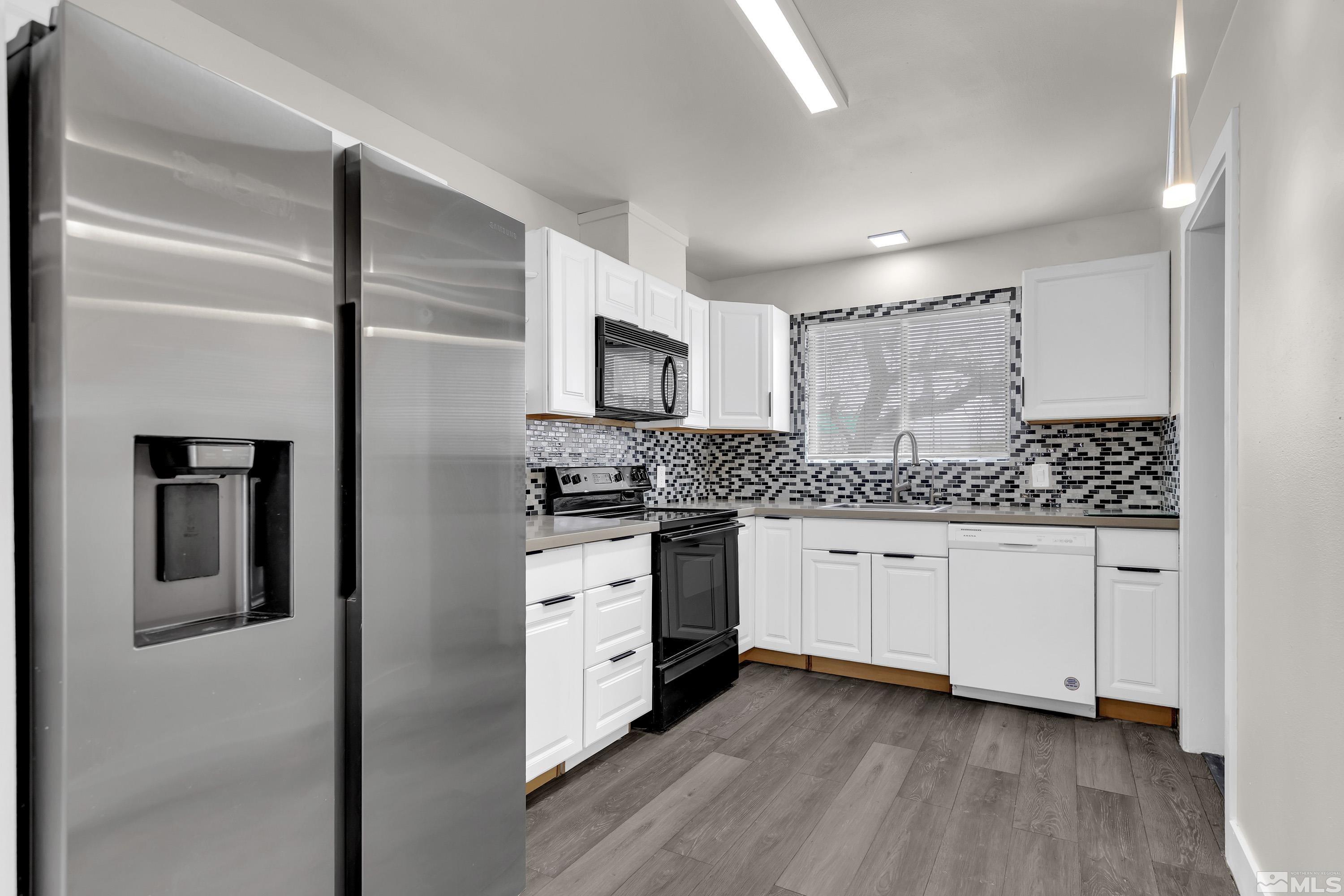 4 Smithridge Park Reno, NV 89502 - Photo 19 of 26 a kitchen with granite countertop white cabinets and stainless steel appliances