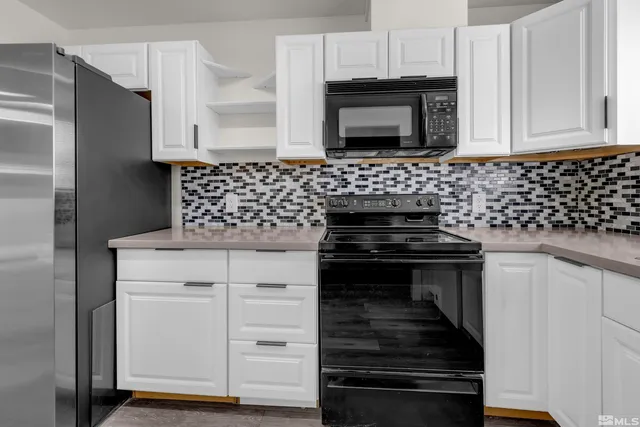 a kitchen with granite countertop white cabinets and stainless steel appliances