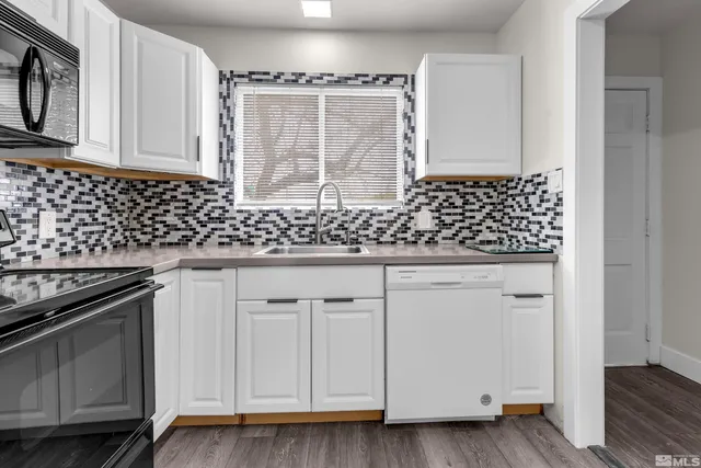 a kitchen with granite countertop white cabinets and black appliances