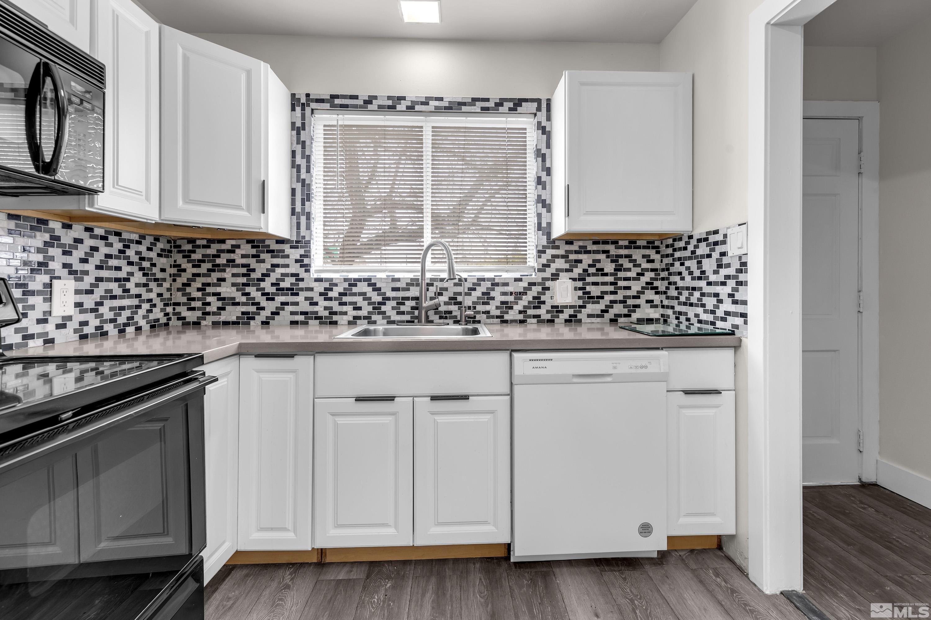 4 Smithridge Park Reno, NV 89502 - Photo 21 of 26 a kitchen with granite countertop white cabinets and black appliances