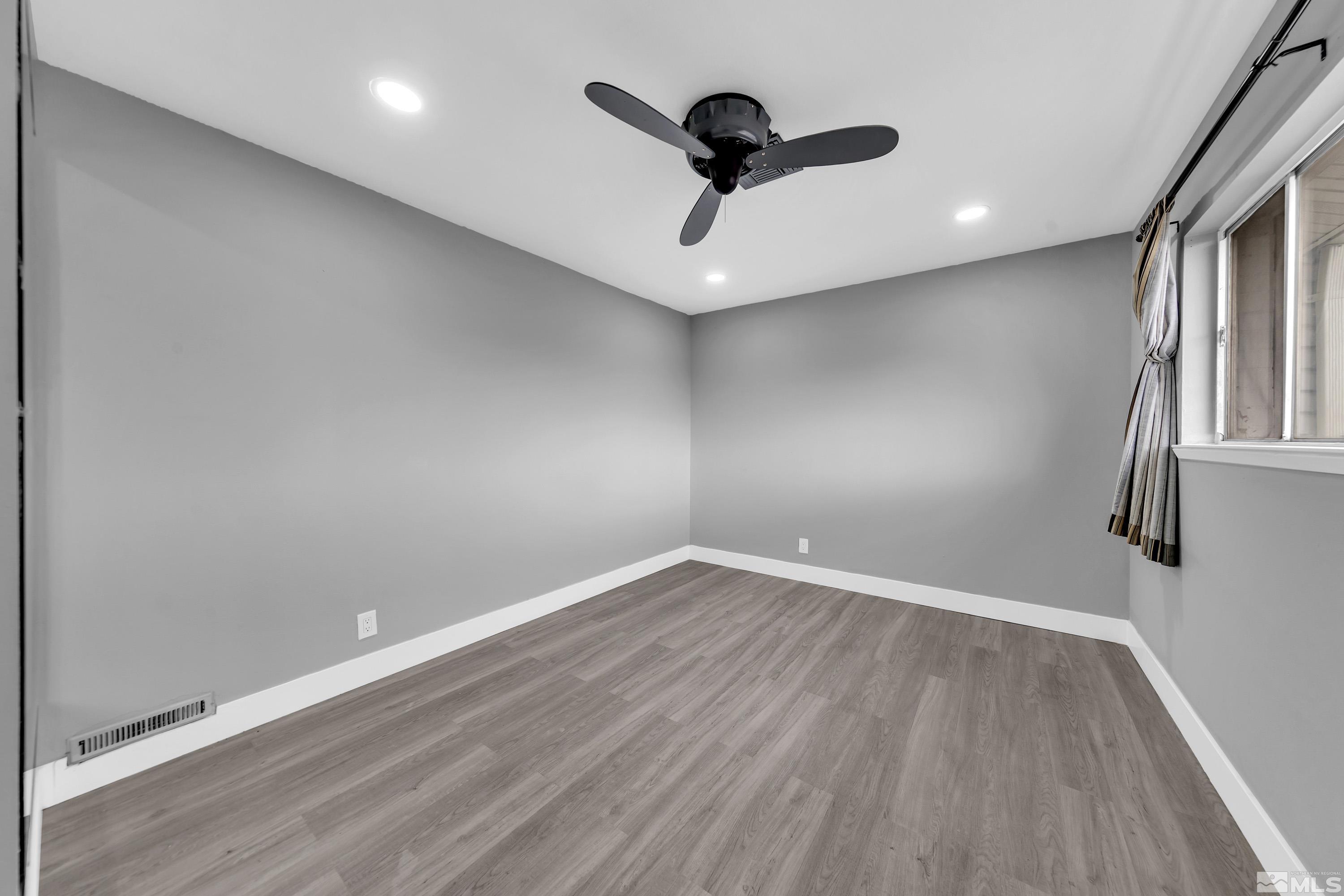 4 Smithridge Park Reno, NV 89502 - Photo 3 of 26 an empty room with wooden floor and windows