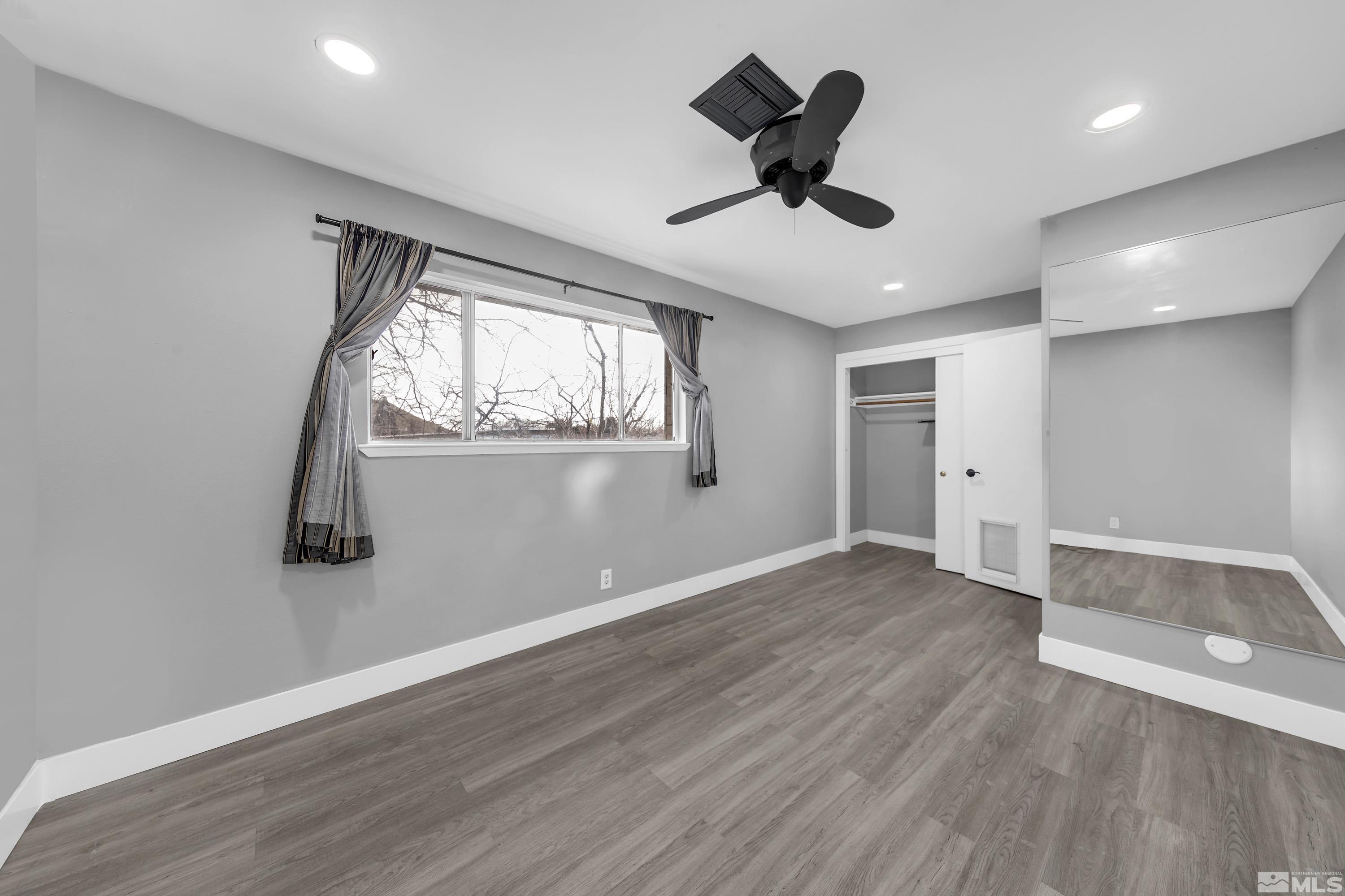 4 Smithridge Park Reno, NV 89502 - Photo 6 of 26 a view of an empty room with wooden floor and a window