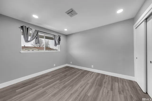 a view of empty room with wooden floor