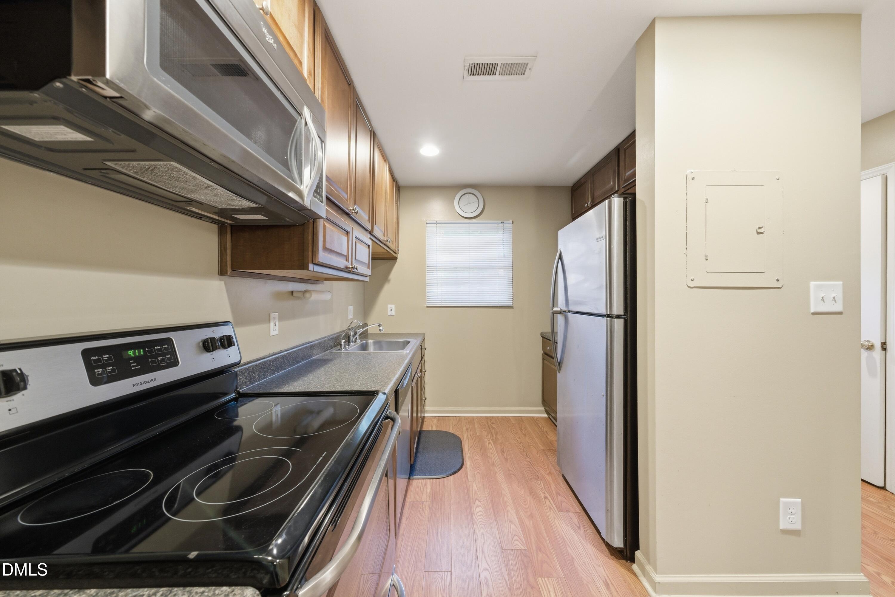 6355 New Market Way Raleigh, NC 27615 - Photo 11 of 30 a view of a refrigerator in kitchen and an empty room
