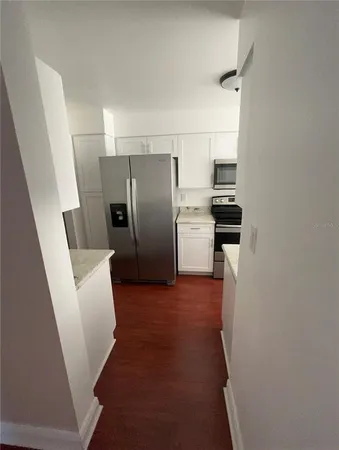 a kitchen with refrigerator and white cabinets