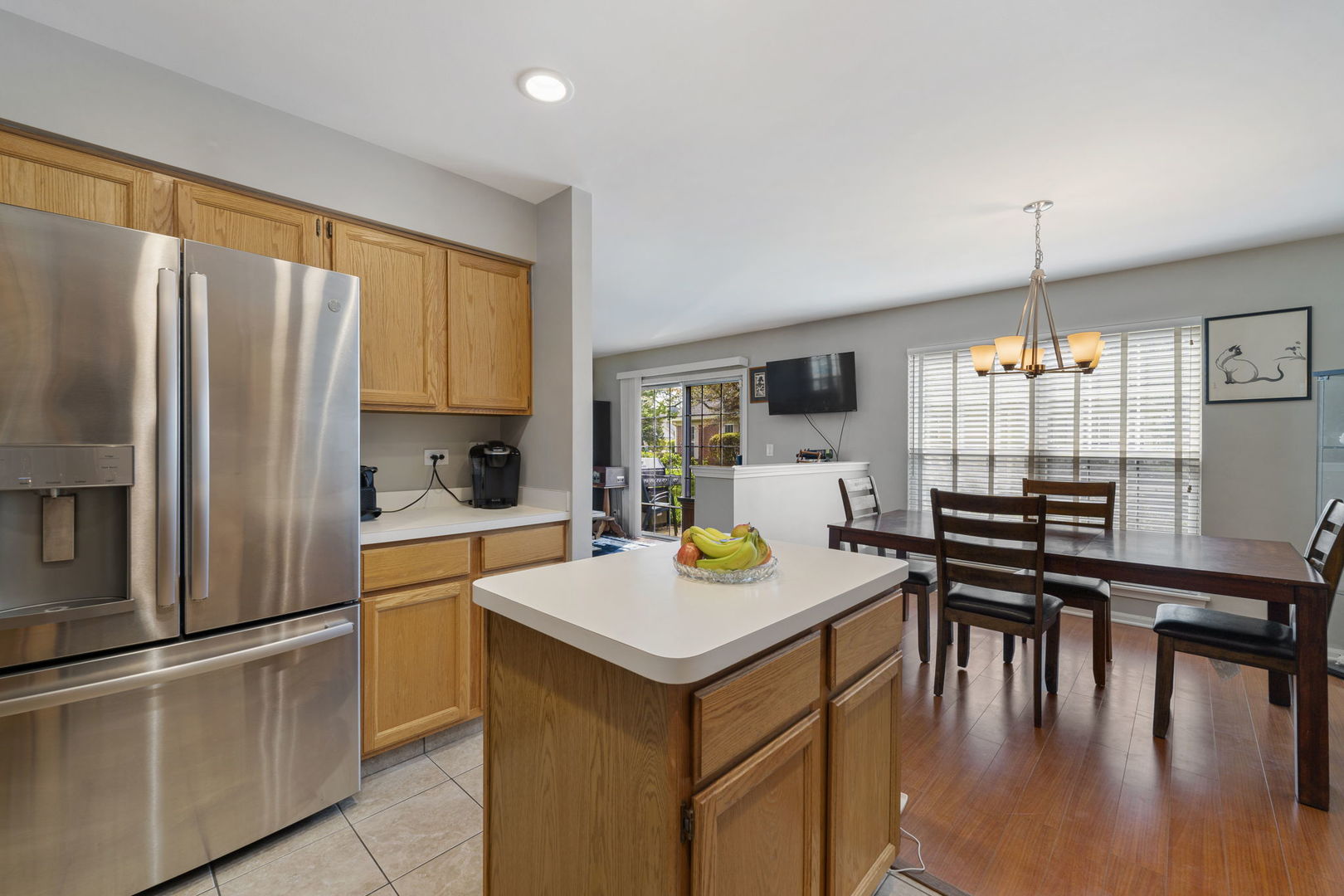 36132 North Springbrook Lane Gurnee, IL 60031 - Photo 13 of 30 a kitchen with stainless steel appliances granite countertop a stove top oven a refrigerator a dining table and chairs with wooden floor