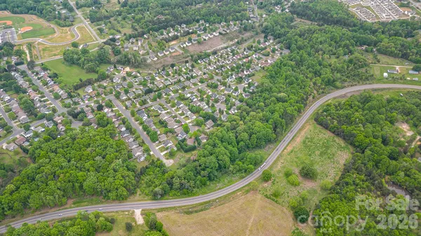 an aerial view of residential houses with outdoor space and trees